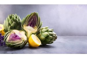 Verse artisjokken en citroen op een betonnen ondergrond – natuurlijke ingrediënten die de lever ondersteunen tijdens een lente detox.